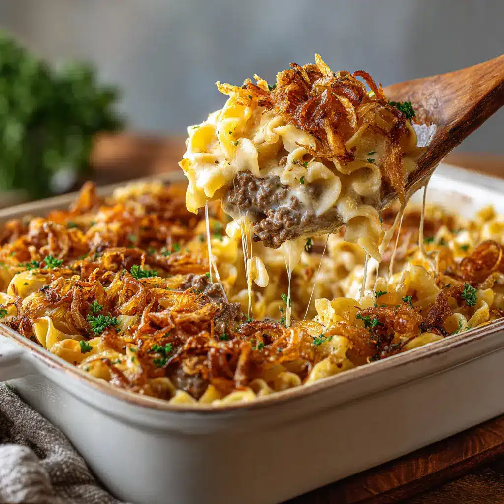 A fork lifting a bite of the beef and noodle bake from a plate, with a cheese pull effect from the melted Gruyère.