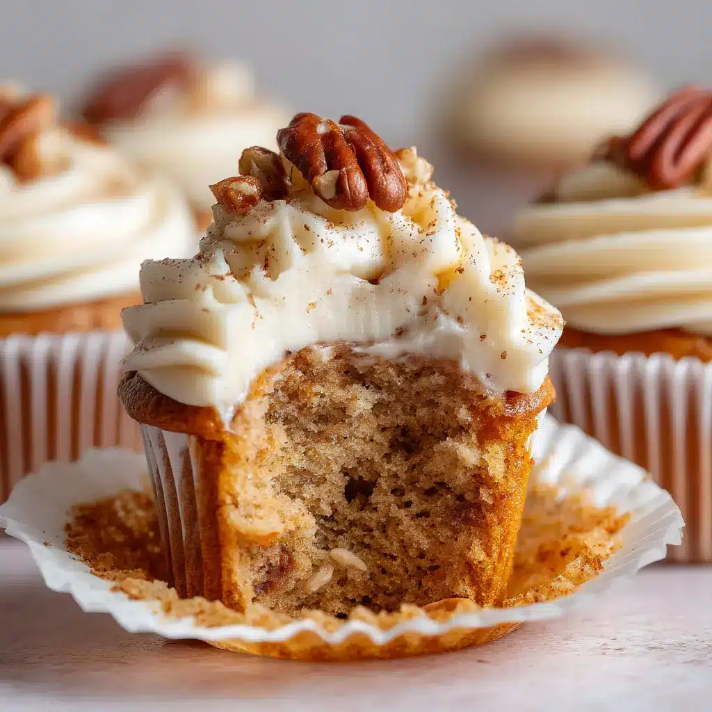 A close-up shot of the rich and tangy cream cheese frosting being swirled onto a banana cupcake.
