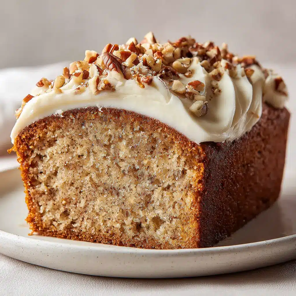 Close-up of thick, swooping opaque white cream cheese icing topped with coarse dry-roasted chopped pecan pieces.