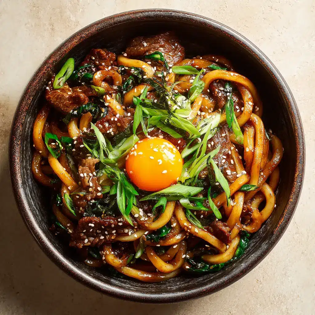 A bowl of Japanese stir-fried udon noodles, garnished with fresh green onions and sesame seeds.