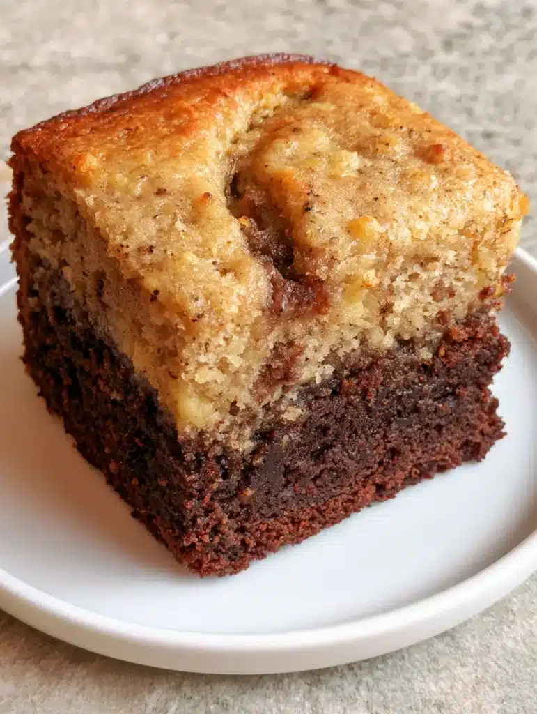 High angle close up of a Banana Bread Brownie square with visible banana specks and a dark brownie base.