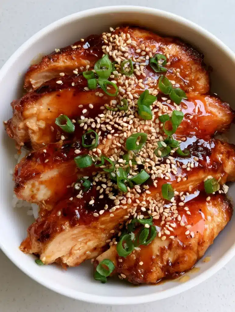Top view of Honey Garlic Chicken Breasts heavily coated in a dark amber honey garlic sauce with toasted sesame seeds.